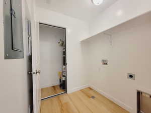 Laundry room featuring washer hookup, electric panel, electric dryer hookup, and vinyl plank/ wood-style floors. Utility room with water heater off of Laundry