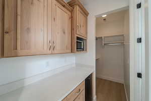 Kitchen featuring light brown cabinets, light wood-type flooring, and light stone counters