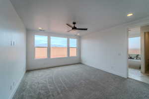 Carpeted empty room with a mountain view and ceiling fan