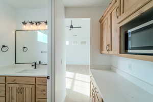 Bathroom featuring hardwood / wood-style flooring, ceiling fan, and vanity