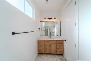 Bathroom featuring vanity and an enclosed shower