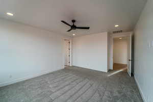 Carpeted spare room with ceiling fan