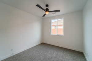 Carpeted empty room with ceiling fan