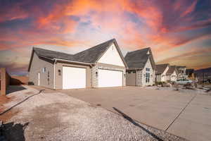 Property exterior at dusk with a garage and central AC unit