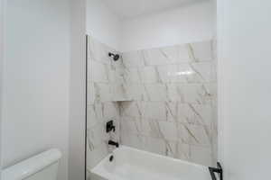 Bathroom with toilet and tiled shower / bath