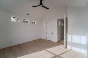 Empty room featuring ceiling fan, light hardwood / wood-style flooring, and lofted ceiling