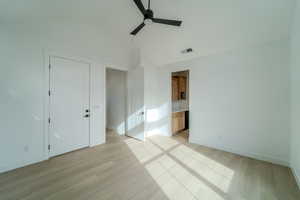 Unfurnished room featuring light wood-type flooring, high vaulted ceiling, and ceiling fan