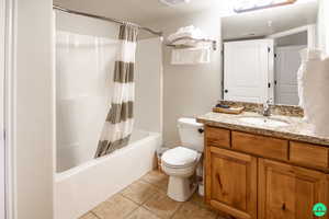 Bathroom featuring vanity, shower / bath combo and cleaning closet