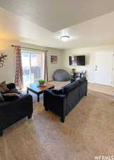 Living room featuring light carpet and a textured ceiling