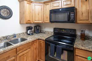Kitchen with black appliances and light stone counters