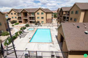 Community pool with a patio area and a hot tub.
