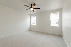 Carpeted empty room featuring ceiling fan