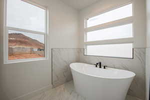 Bathroom featuring a tub to relax in and a healthy amount of sunlight