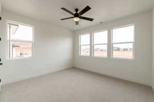 Spare room with ceiling fan and light carpet