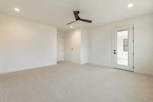 Empty room with ceiling fan and light carpet