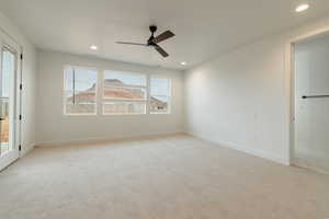 Spare room featuring ceiling fan and light carpet