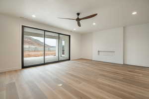 Spare room with ceiling fan, a mountain view, and light wood-type flooring