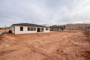 Rear view of house featuring a patio area, a mountain view, and central AC unit