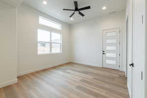 Empty room with light hardwood / wood-style floors and ceiling fan