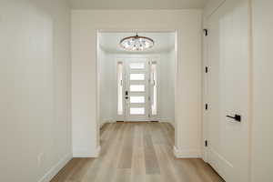 Foyer featuring light hardwood / wood-style flooring and a chandelier