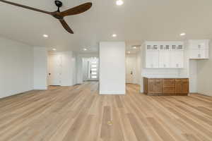 Unfurnished living room with light hardwood / wood-style floors and ceiling fan