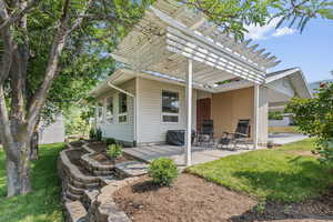 Rear view of house featuring a yard, a pergola, and a patio area