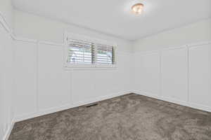 Unfurnished room with dark carpet