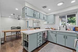 Kitchen with a wealth of natural light, dishwasher, sink, tasteful backsplash, and kitchen peninsula