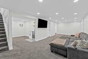 Living room with carpet flooring, crown molding, wine cooler, and indoor bar