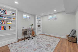 Office with wood-type flooring and built in features