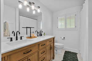 Bathroom featuring tile patterned flooring, vanity, and toilet