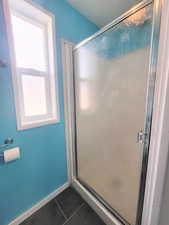 Bathroom featuring tile patterned flooring and a shower with shower door