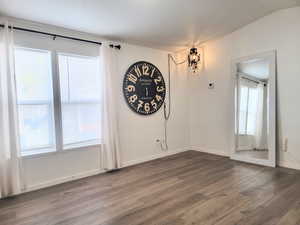 Unfurnished room featuring hardwood / wood-style flooring and lofted ceiling