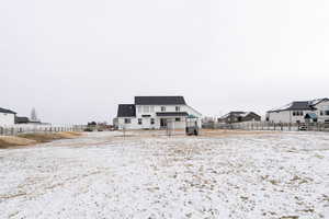 View of snow covered back of property