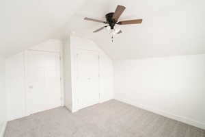 Bonus room featuring ceiling fan, light colored carpet, and vaulted ceiling