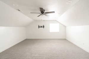 Bonus room with carpet flooring, a textured ceiling, ceiling fan, and lofted ceiling