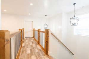 Corridor with a notable chandelier and light hardwood / wood-style flooring