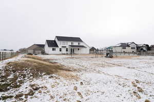 View of snow covered back of property