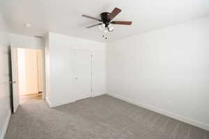 Unfurnished bedroom with a closet, light colored carpet, and ceiling fan