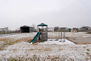 Snow covered playground featuring an outdoor structure