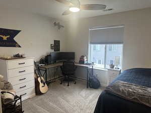 Carpeted bedroom featuring ceiling fan