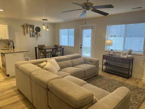 Living room featuring ceiling fan, sink, and light hardwood / wood-style flooring