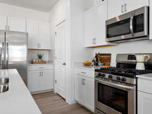 Kitchen with white cabinetry and stainless steel appliances