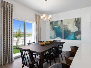 Dining space featuring hardwood / wood-style floors, a notable chandelier, and plenty of natural light