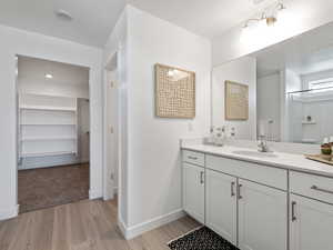 Bathroom featuring a shower, vanity, and wood-type flooring