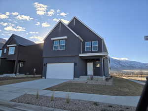 View of front of home with a mountain view and a garage