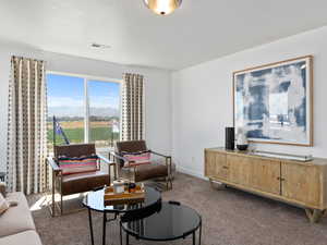 Living room featuring carpet flooring, a mountain view, and a textured ceiling