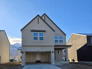 View of front of property with a mountain view and a garage