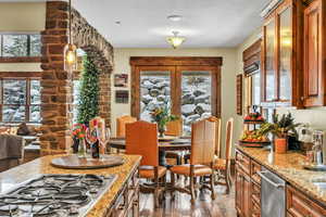 Dining area beyond kitchen featuring french doors opening to covered patio