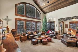 Very spacious living room with towering, vaulted ceiling, trimmed out in wood